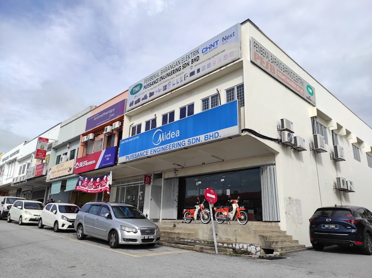 Corner shop lot with a white Puissance Engineering signboard and a large blue Midea sign