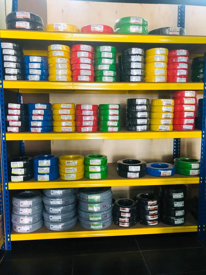 Blue and yellow steel shelving stacked with coils of red, yellow, green, blue and black cable