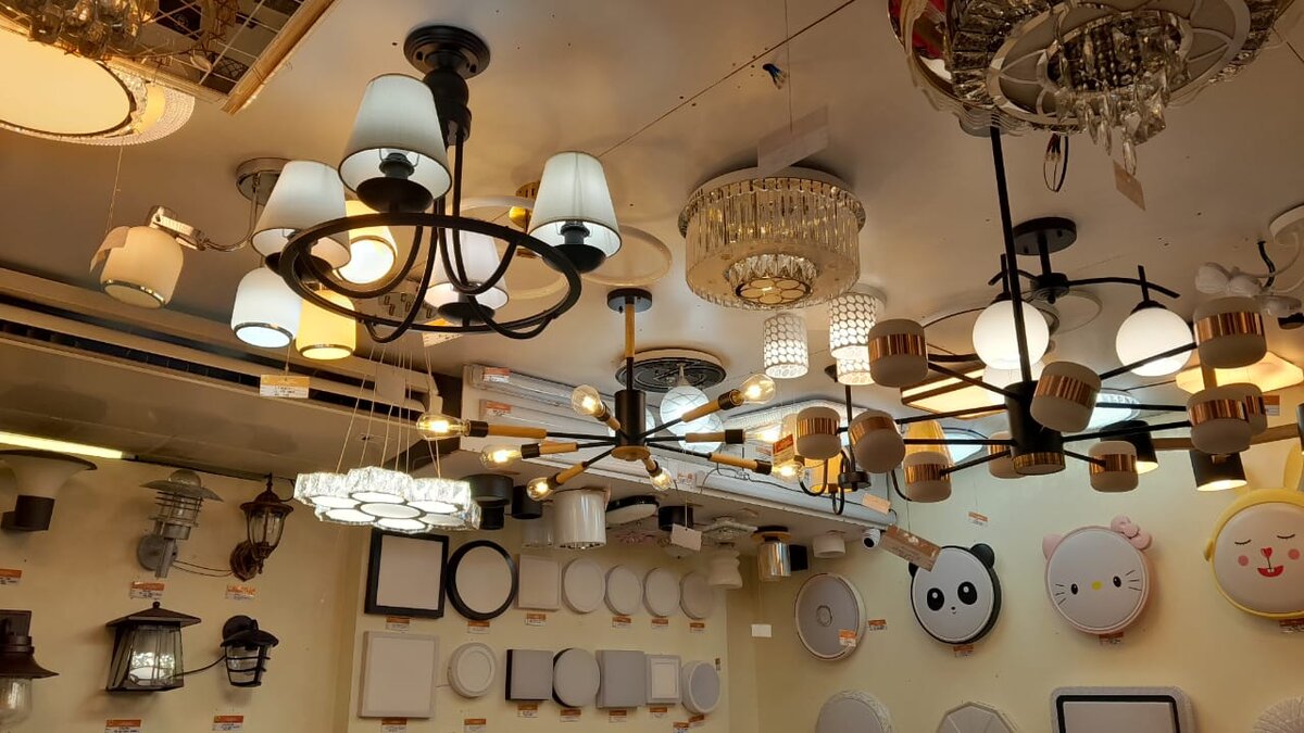 Shop ceiling hung with chandeliers and pendant lamps above walls of round and square ceiling lights