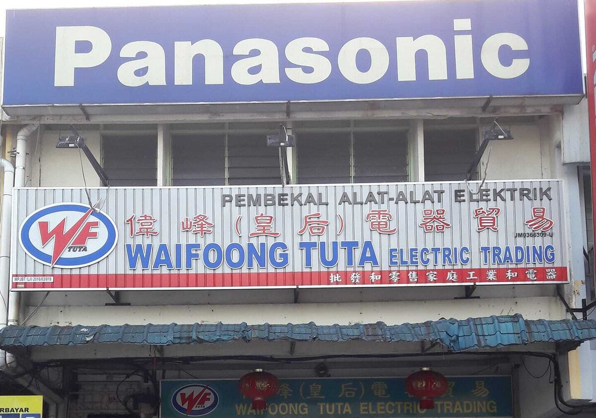 Shop signboard reading Waifoong Tuta Electric Trading with a WF logo and Chinese characters, under a large blue Panasonic sign, with a second shop sign above the entrance