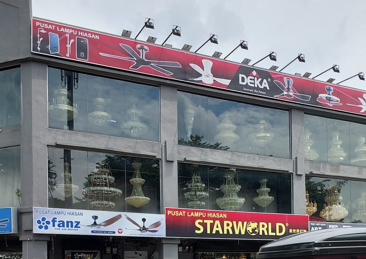 Three-storey glass shopfront with chandeliers in every window, a red Deka fan banner along the roof and Fanz and Starworld signboards above the ground floor