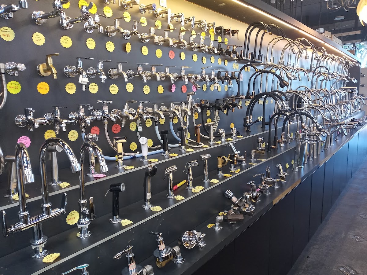 Long black display wall lined with chrome taps and kitchen mixers with yellow price tags