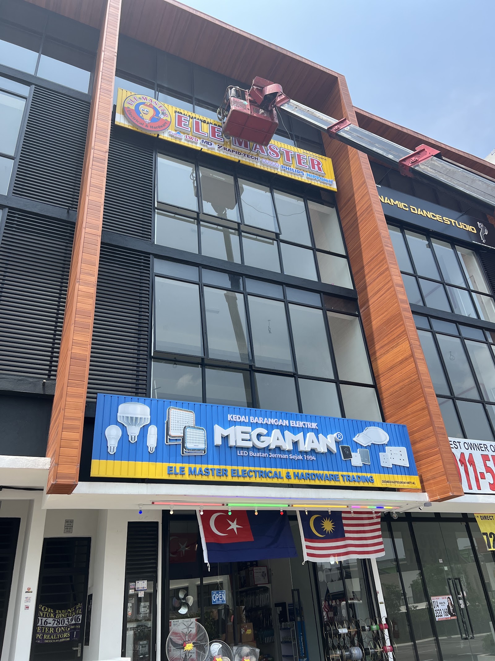 Modern three-storey shophouse with a yellow ELE Master signboard above and a blue Megaman signboard over the entrance