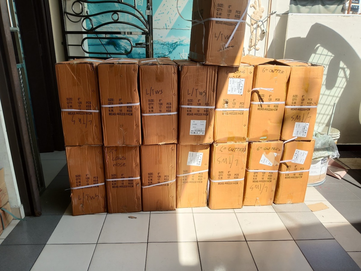 A row of brown cartons stacked two high in a shop doorway, labelled 6 inch, 120 pieces, long nose and cutter