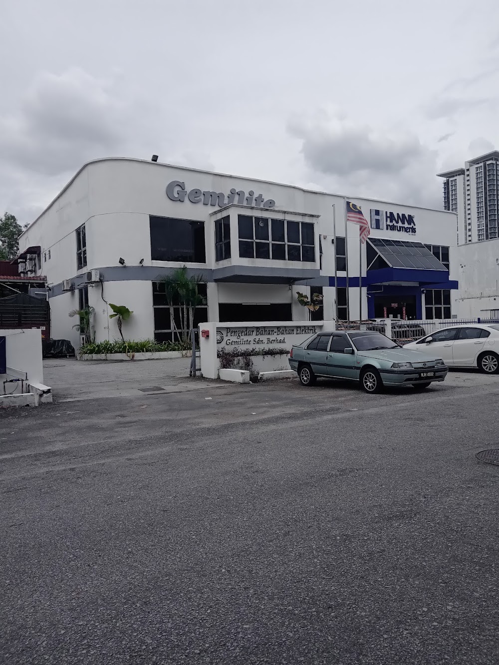 White two-storey commercial building with a Gemilite logo on the facade and a low wall sign in front