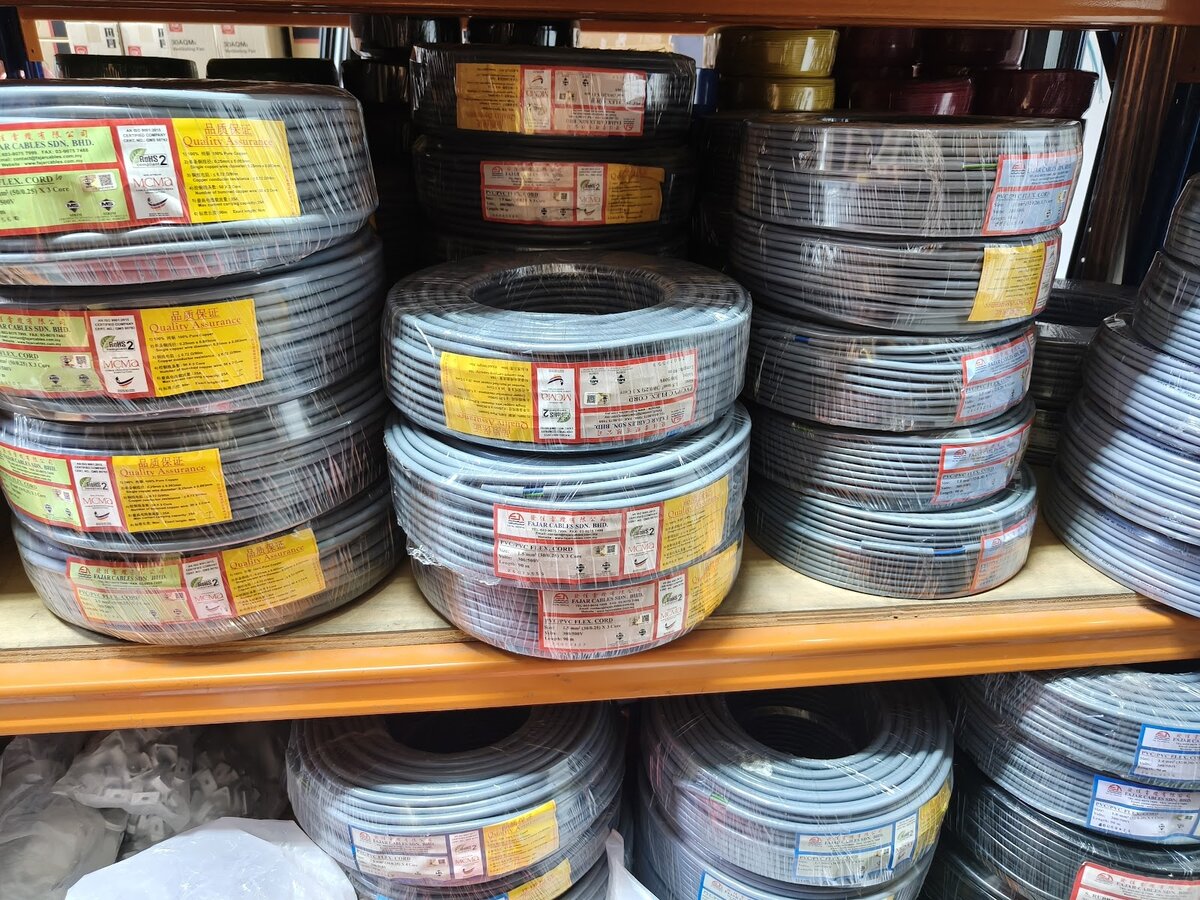 Shelves stacked with grey cable coils wrapped in plastic with yellow Fajar Cables labels