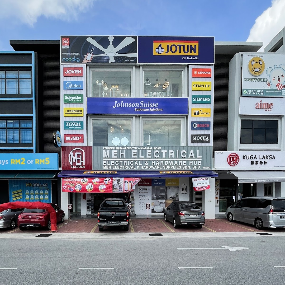 Three-storey shoplot with an MEH Electrical & Hardware Hub signboard, a Jotun sign and brand logos on both sides of the upper floors