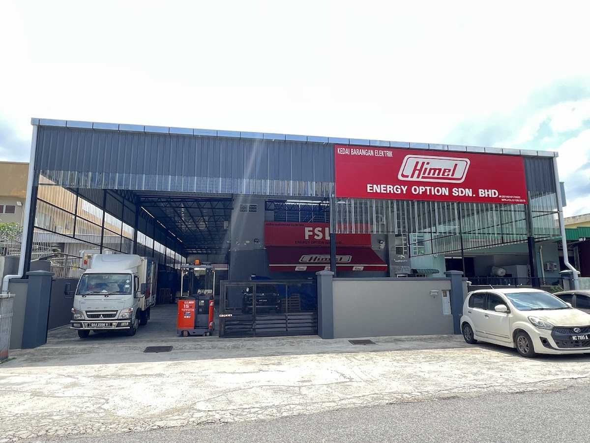 Large warehouse with a red Himel signboard reading Energy Option Sdn Bhd, Kedai Barangan Elektrik, an FSL sign behind, a lorry and a forklift