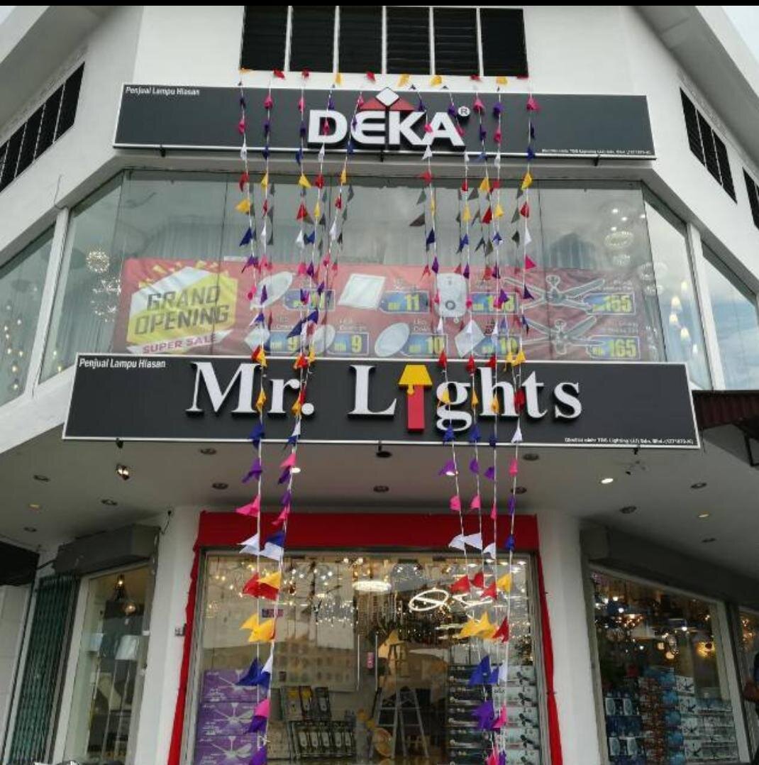 Corner shop with a black "Mr. Lights" fascia, a Deka signboard above, festive bunting and pendant lights behind the glass