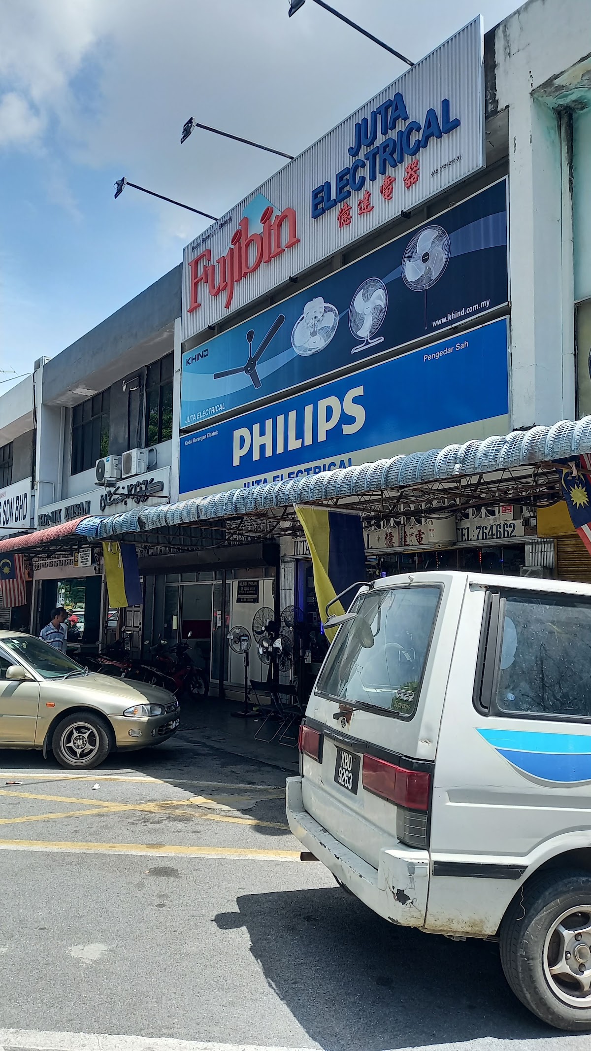 Shop front with a Fujibin and Juta Electrical signboard above a Khind fan banner and a blue Philips sign