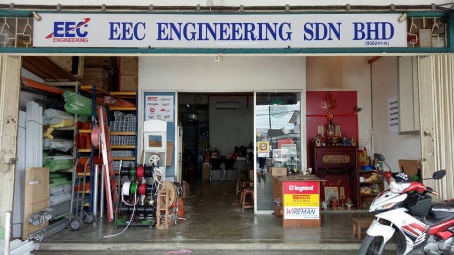 Open shopfront under a white EEC Engineering Sdn Bhd signboard with cable reels and shelving