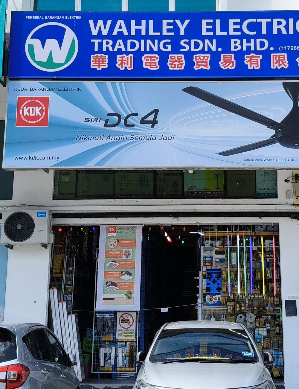 Shopfront with a blue Wahley Electrical Trading signboard, a KDK DC4 ceiling fan panel below it and electrical goods hanging at the open entrance