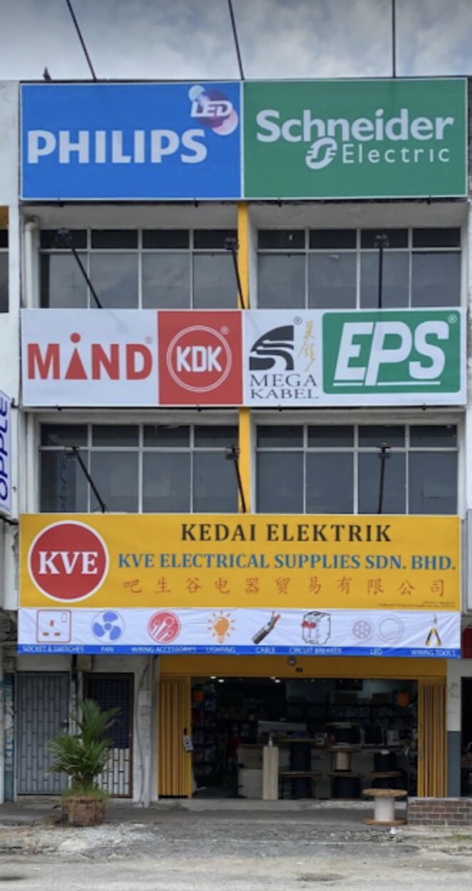 Three-storey shop with Philips and Schneider Electric signs at the top and a yellow KVE Kedai Elektrik signboard at street level