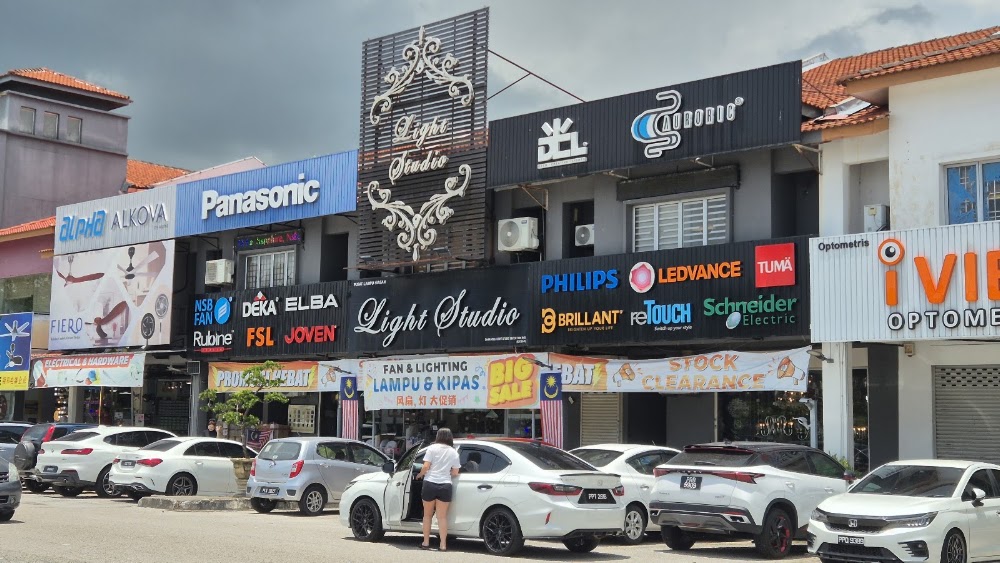 Row of shoplots with an ornate Light Studio sign and brand signboards for Philips, Ledvance, Schneider Electric, Panasonic and others