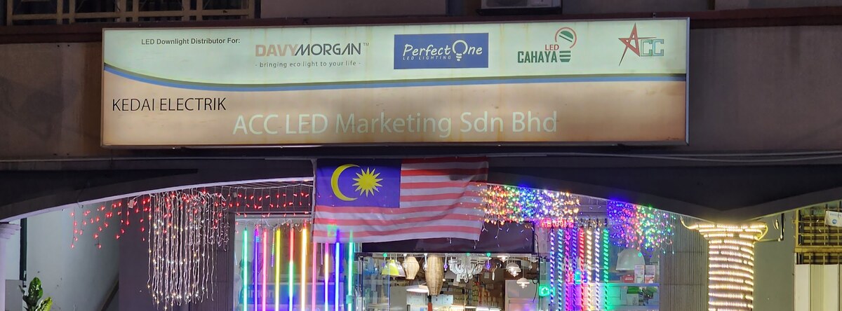 Lit shop sign for ACC LED Marketing with Davy Morgan, Perfect One and LED Cahaya logos above a shopfront decorated with colourful LED strings and tubes