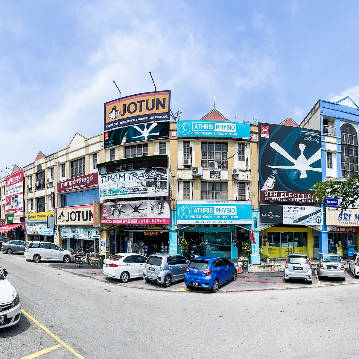 Row of shophouses with a Jotun Kedai Cat MEH sign and a KDK ceiling-fan billboard over the MEH shopfront