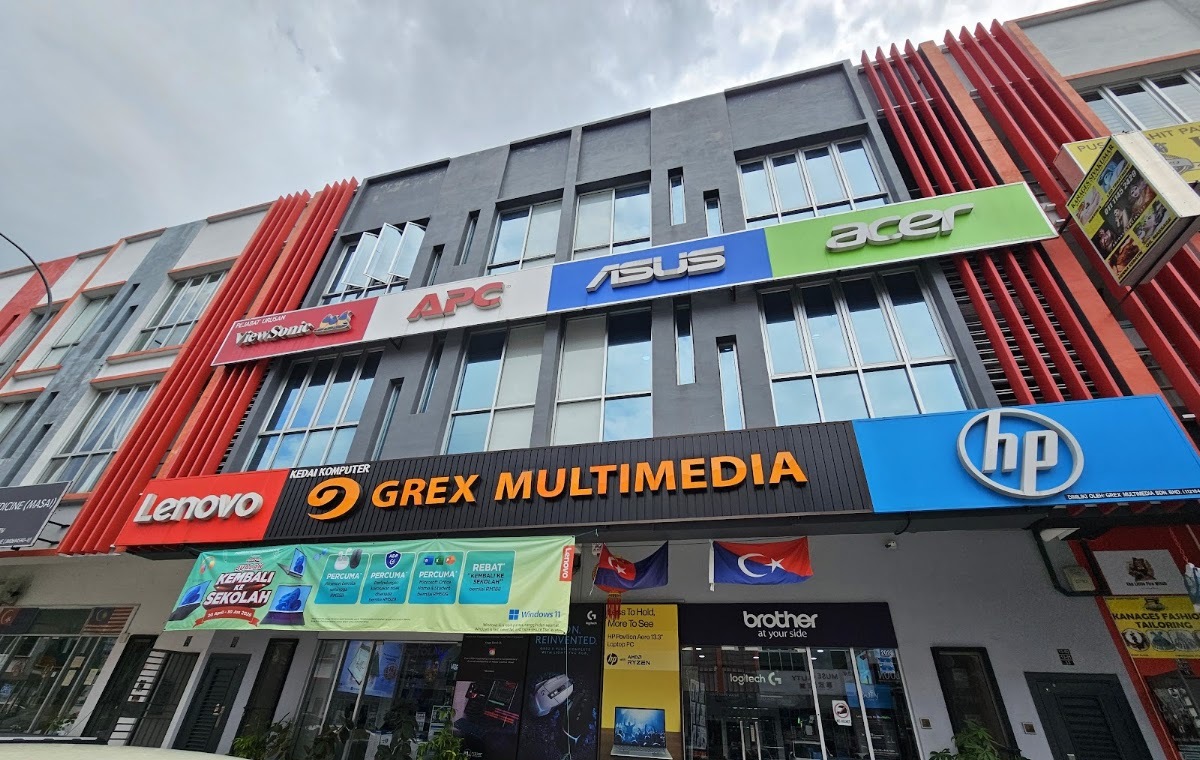 Three-storey shop lot with a Grex Multimedia signboard flanked by Lenovo and HP logos, and APC, Asus and Acer signs above