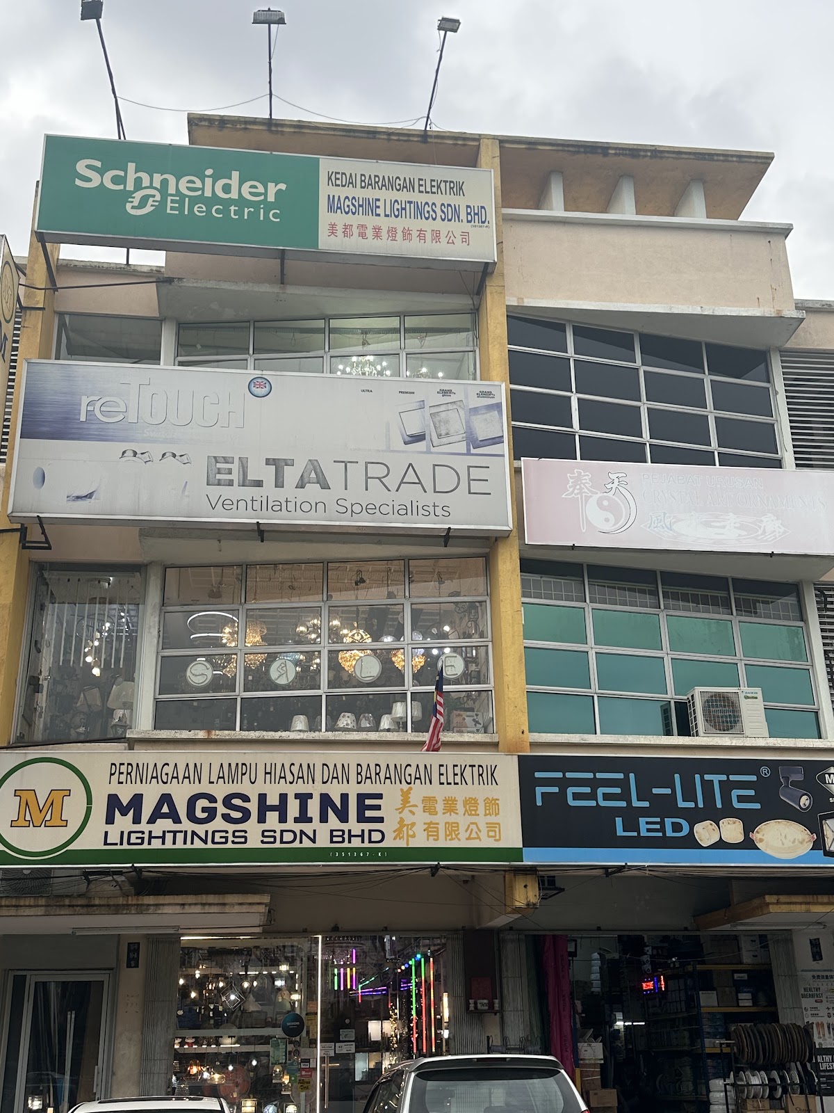 Shophouse with a green Schneider Electric sign at the top and a Magshine Lightings signboard above the ground floor
