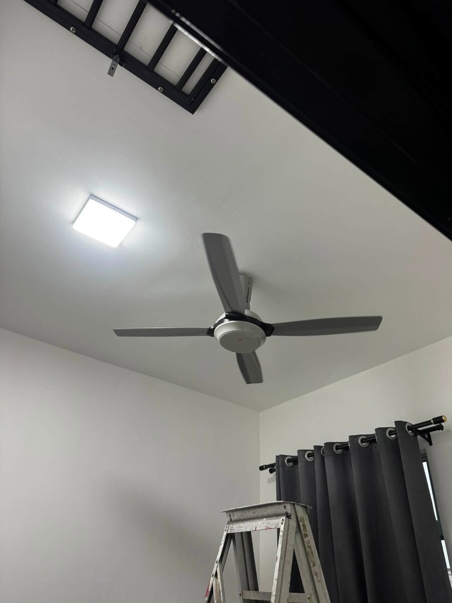 Room ceiling with a newly installed grey four-blade ceiling fan and a square LED panel light, a step ladder below