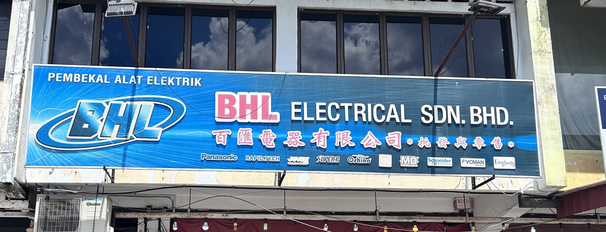 Blue BHL Electrical Sdn Bhd signboard with a row of brand logos