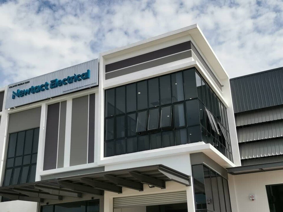 Modern two-storey industrial unit with a signboard reading Kilang Papan Suis, Newtact Electrical