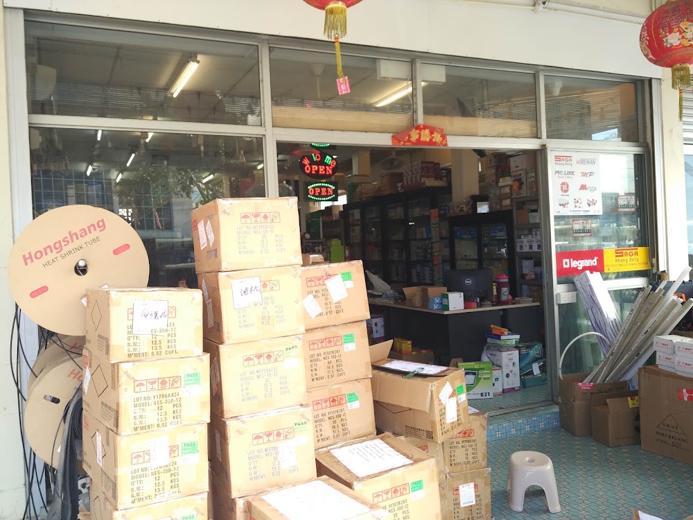 Glass shopfront crowded with cardboard boxes and Hongshang heat-shrink tube reels, a Legrand sign inside the door