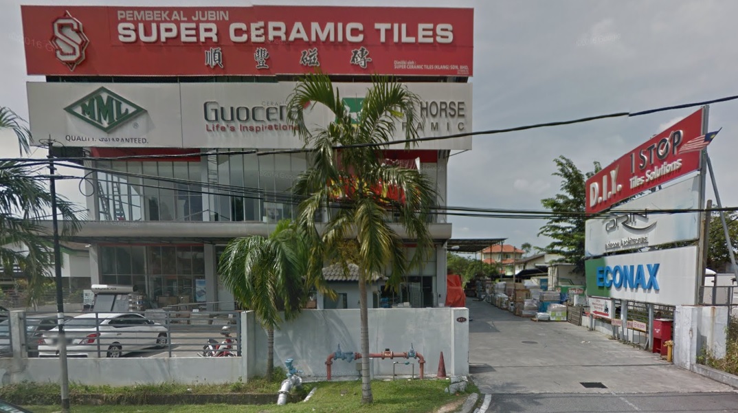 Red Super Ceramic Tiles signboard over a showroom building with tile brand signs and a D.I.Y. 1 Stop sign at the gate