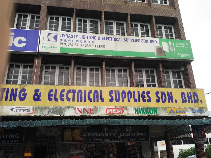Shop building with a green Dynasty Lighting signboard showing Schneider Electric and a yellow fascia with brand logos