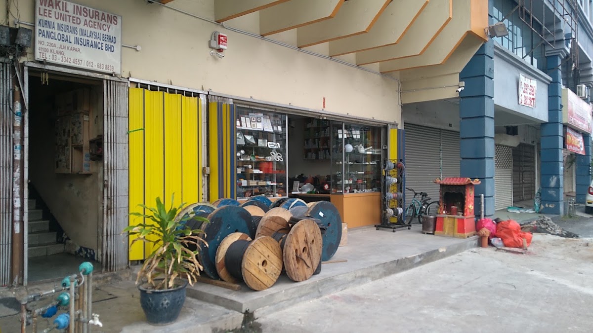 Shopfront with yellow folding doors, wooden cable drums on the walkway and display cabinets inside