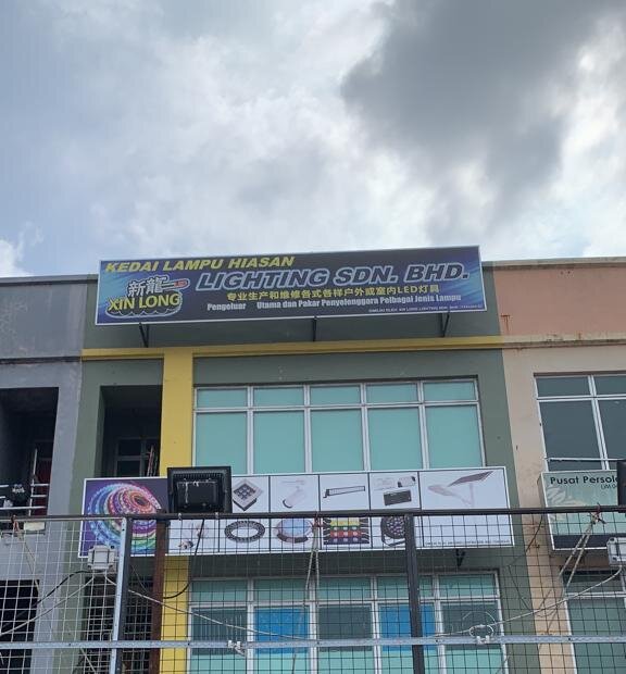 Three-storey shophouse with a blue "Kedai Lampu Hiasan Xin Long Lighting Sdn. Bhd." signboard on the top floor and a second signboard above the shop