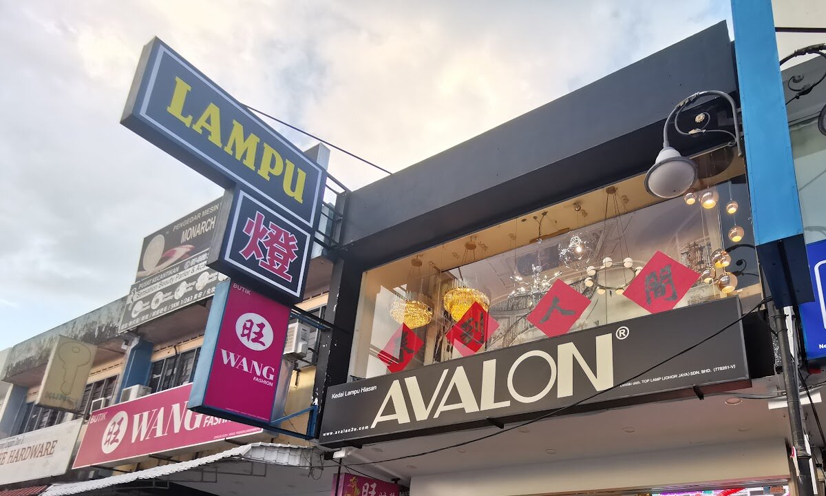 Shophouse with a black AVALON fascia, a LAMPU projecting sign and chandeliers visible in the upper window