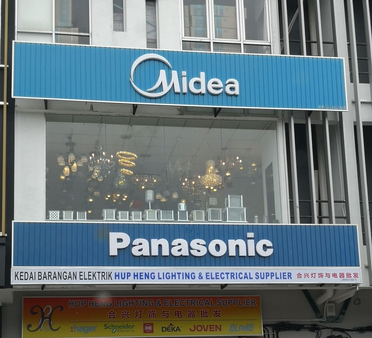 Shop building with Midea and Panasonic fascias, chandeliers in the first-floor window and a yellow Hup Heng Lighting and Electrical Supplier sign at street level