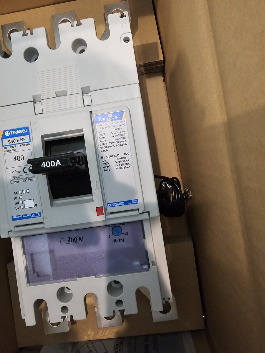 Grey Terasaki S400-NF moulded-case circuit breaker with a 400A handle label lying in an open cardboard box