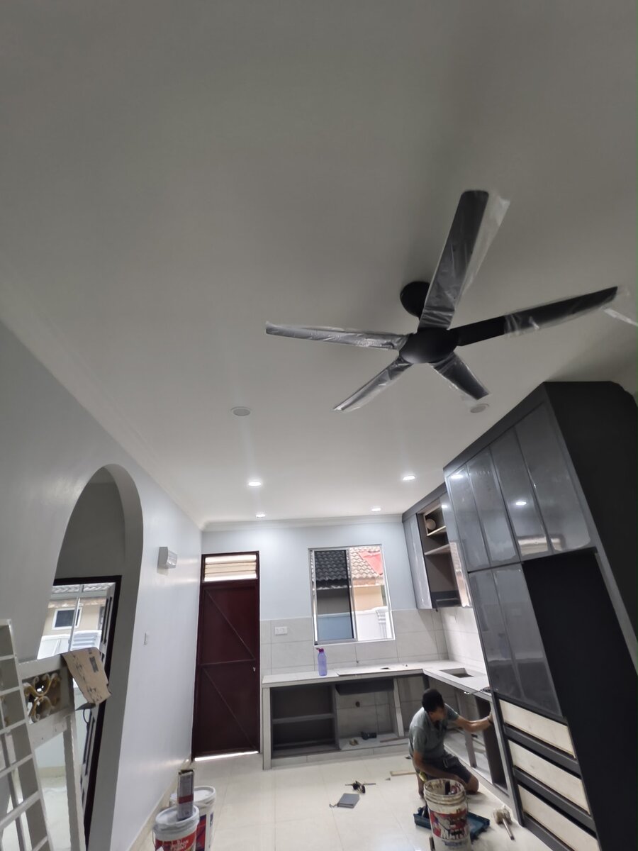 Bright house kitchen with a five-blade ceiling fan still in plastic wrap, recessed downlights and a worker fitting cabinets