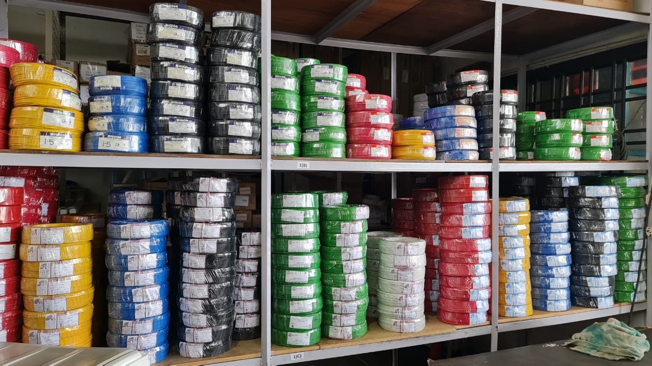 Shelves stacked with coils of red, yellow, blue, green, black and white electrical wire