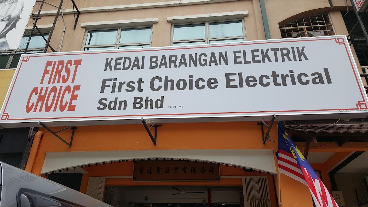 White shop signboard reading First Choice, Kedai Barangan Elektrik, First Choice Electrical Sdn Bhd above an orange shopfront