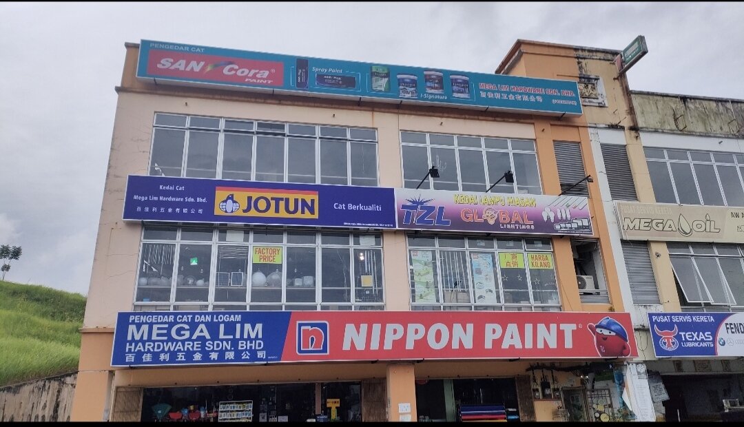 Three-storey corner shophouse with a SanCora Paint board on top, Jotun and TZL Global Lightings signs on the first floor and a Mega Lim Hardware Nippon Paint signboard over the ground floor