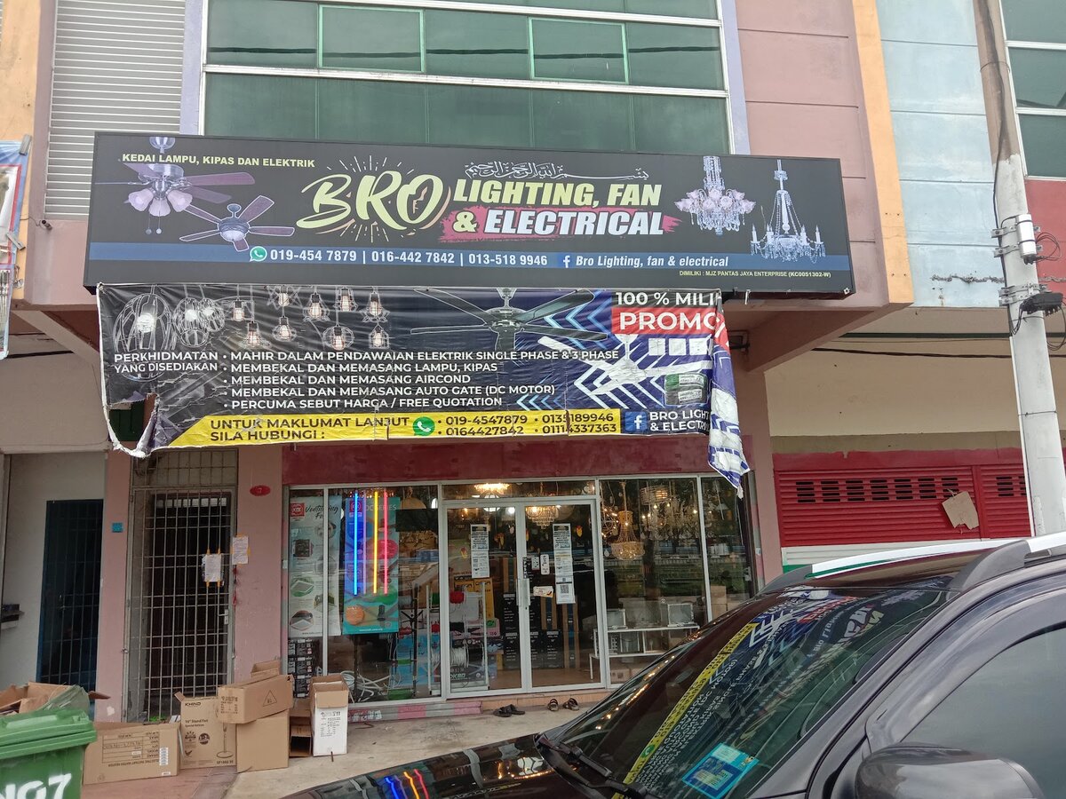 Shopfront with a black Bro Lighting, Fan & Electrical signboard, a services banner and chandeliers visible through the glass door
