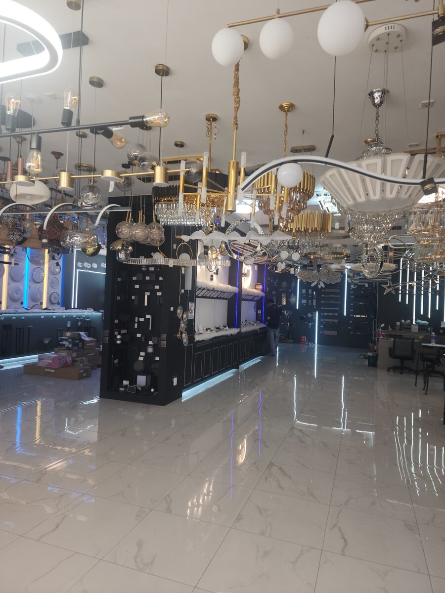 Bright showroom with a polished floor and globe, ring and gold pendant lights hanging from the ceiling