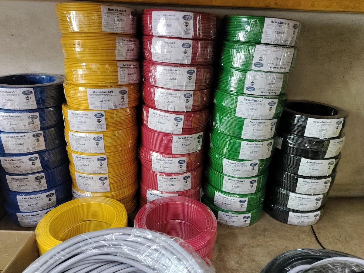 Stacks of blue, yellow, red, green and black single-core cable coils with white ArusSmart labels