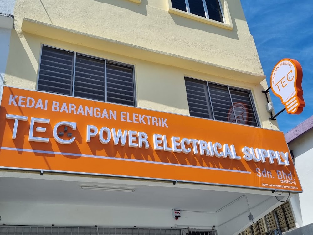 Orange shop signboard reading Kedai Barangan Elektrik TEC Power Electrical Supply Sdn Bhd with a light-bulb shaped TEC sign