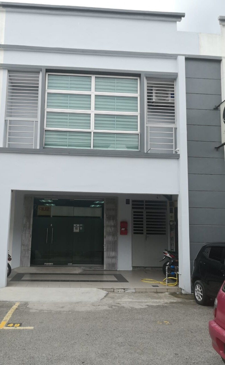 Grey and white two-storey shop-office with a glass double door, a red letterbox and a grilled side door, with parking bays in front