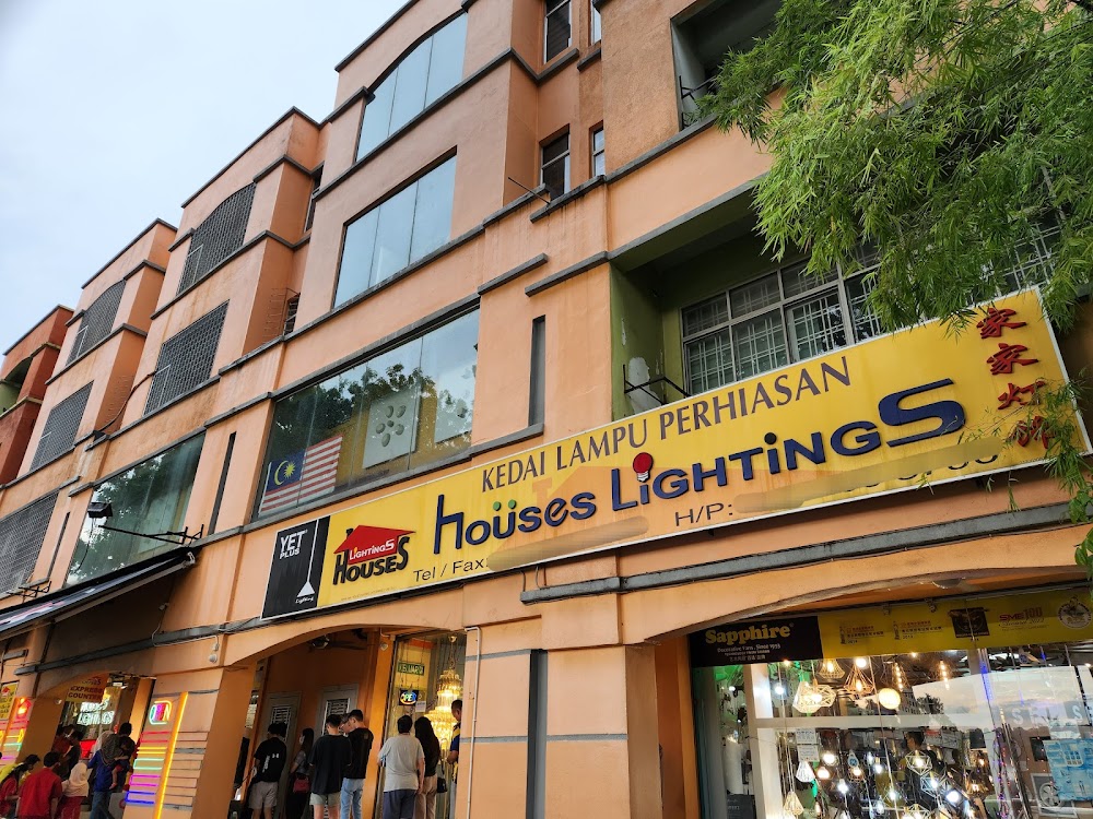 Row of shophouses with a long yellow signboard reading Kedai Lampu Perhiasan Houses Lightings and a lit lighting showroom below