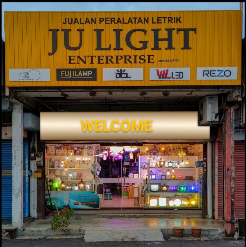 Yellow shop signboard reading JU Light Enterprise above a glass shopfront lit with lamps