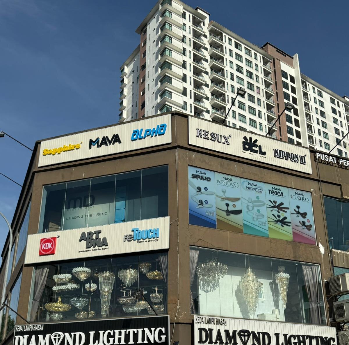 Corner shop block with Diamond Lighting signs at street level and brand signboards for lighting, fan and switch brands above
