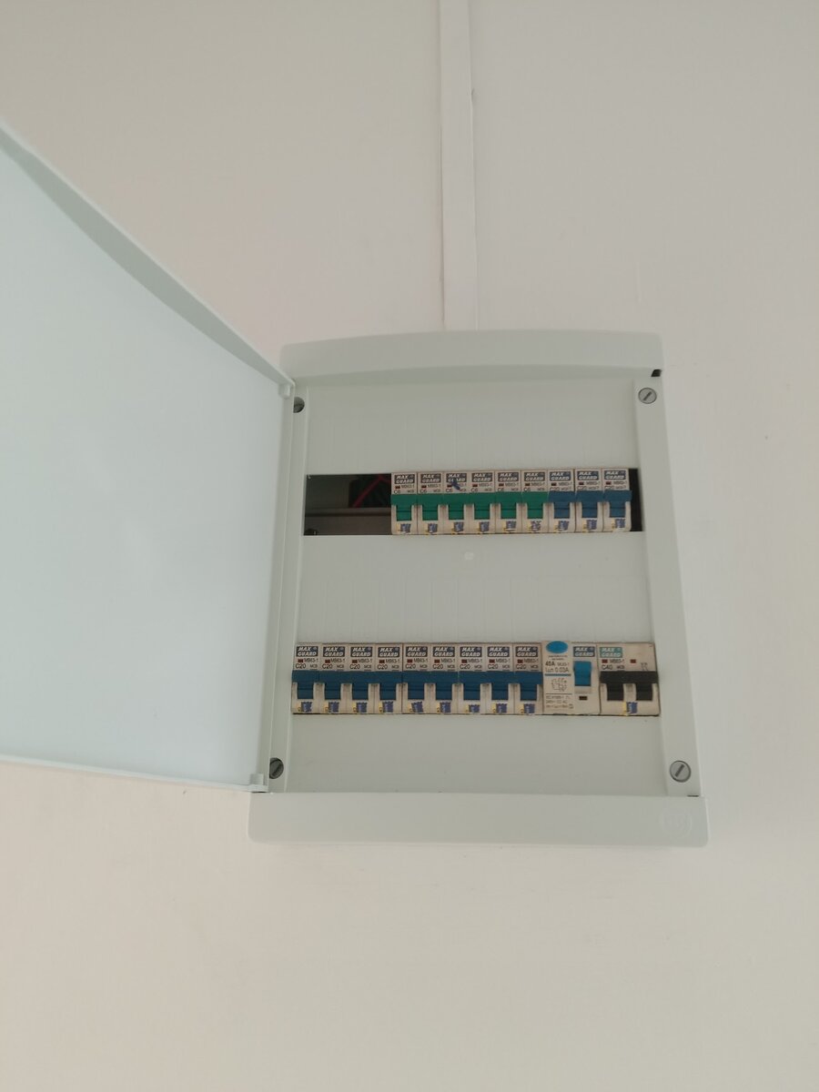 Open white distribution board with two rows of green- and blue-handled Maxguard MCBs, a 40A 30mA RCCB and a black-handled two-pole main breaker