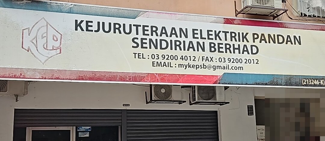 Shop signboard reading Kejuruteraan Elektrik Pandan Sendirian Berhad with a KEP logo, phone 03 9200 4012, fax 03 9200 2012 and an email address, above closed shutters and wall-mounted aircond units