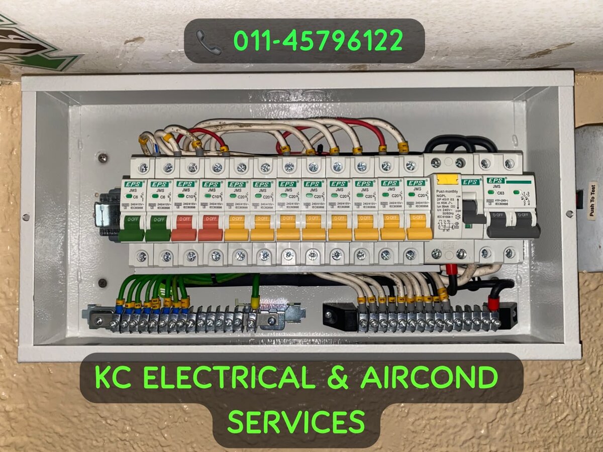 Open distribution board with green, red and yellow-handled miniature circuit breakers, an RCCB and a main switch, watermarked KC Electrical & Aircond Services 011-45796122