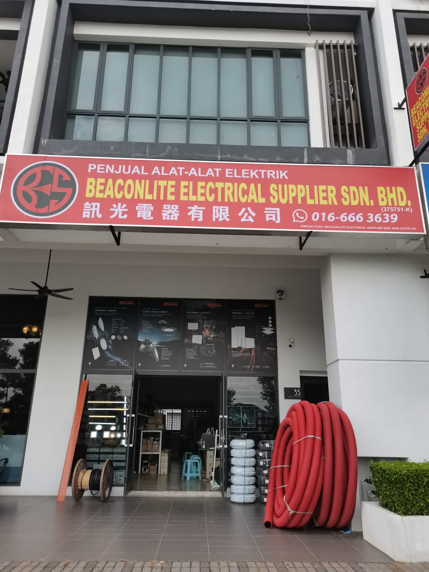 Shopfront with a red Beaconlite Electrical Supplier signboard, cable drum and coils of red conduit outside