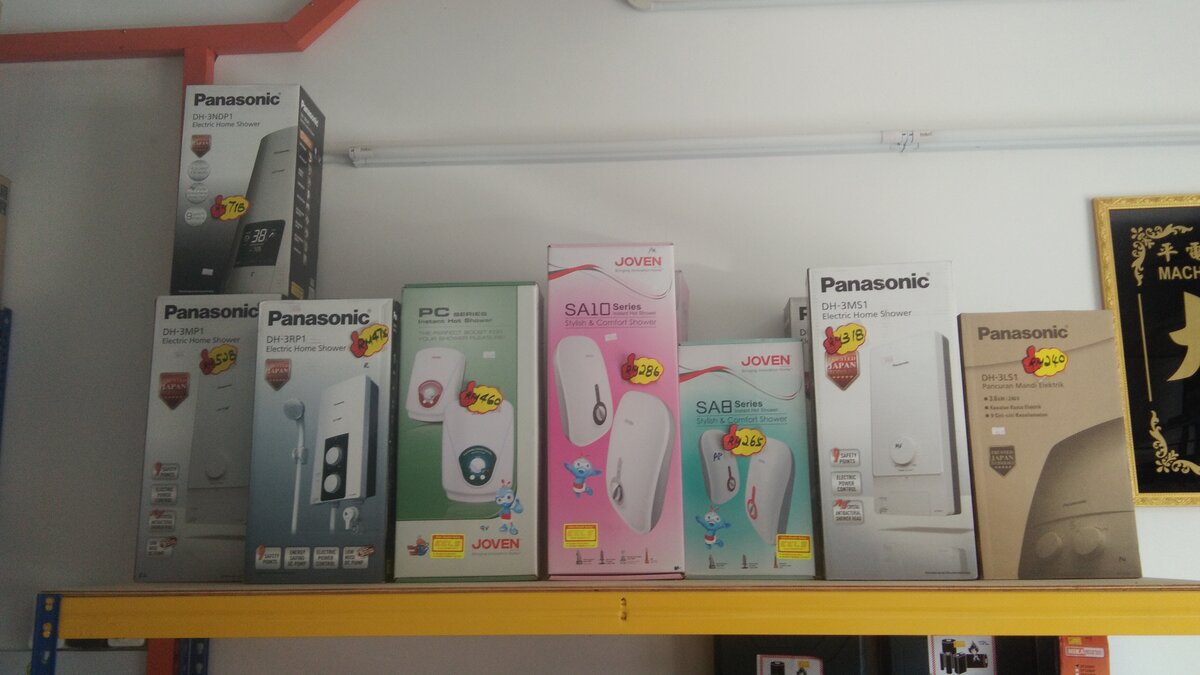 Shelf of Panasonic and Joven water heater boxes with yellow price stickers